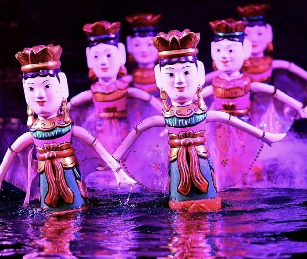 Cận cảnh các con rối bằng gỗ sơn màu, đầu đội mũ hình hoa sen